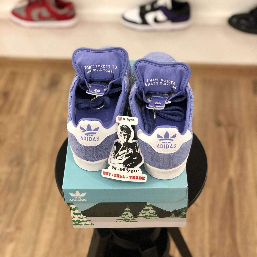 Buty Adidas Campus 80s South Park Towelie — wysokiej jakości zdjęcie produktu przedstawiające trampki w widoku z tyłu. Obraz przedstawia żywą turkusową kolorystykę, napis Towelie wewnątrz języka i logo Adidas z tyłu. Buty są wykonane z materiałów najwyższej jakości, a obraz podkreśla dbałość o szczegóły i kunszt wykonania. Obowiązkowy wybór obuwia dla fanów South Park i entuzjastów sneakersów.