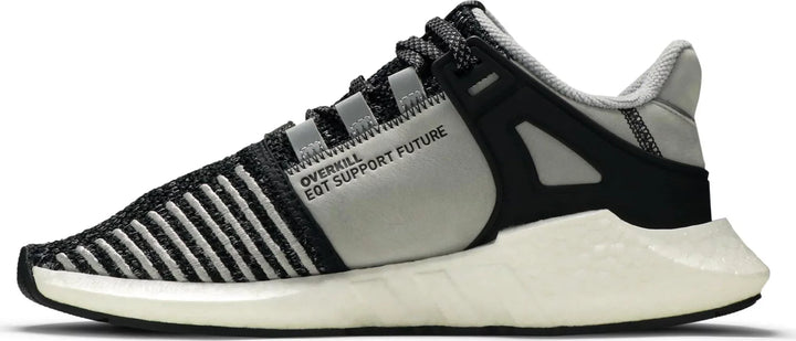 Sneakersy Adidas EQT Support Future Overkill Coat of Arms - dynamiczne i stylowe obuwie o odważnym designie. Zdjęcie przedstawia tenisówki w widoku z boku, podkreślając unikalną grafikę z herbem na cholewce. Trampki charakteryzują się wygodnym krojem i wysokiej jakości konstrukcją, dzięki czemu są idealnym wyborem zarówno dla osób dbających o styl, jak i entuzjastów sneakersów. Wznieś swoją grę w tenisa dzięki tym przyciągającym wzrok tenisówkom adidas EQT.
